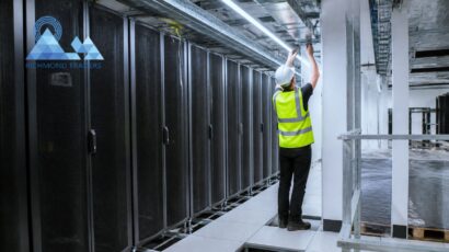 Richmond Traders engineer installing overhead cable tray above server racks during a London data centre fit-out